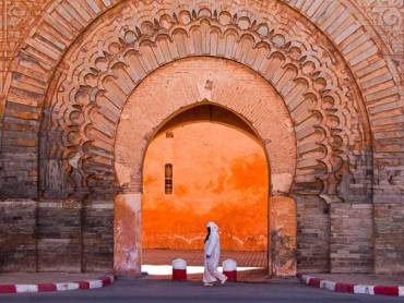 Frau passiert das Bab Agnaou Tor in Marrakesch
